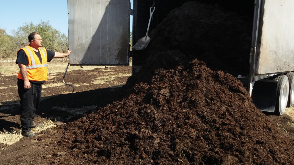 Mushroom compost conveyed out of the trailer by special moving floor mechanism.